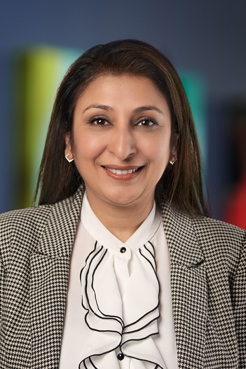 A professional headshot of Priya Almelkar, the Chief Information Officer & SVP